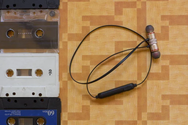 Kasetlerden Yanındaki Siyah Bluetooth Kulaklık — Stok fotoğraf