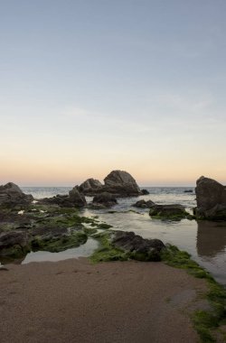 Lloret de Mar gün batımında plaj ve kayalar