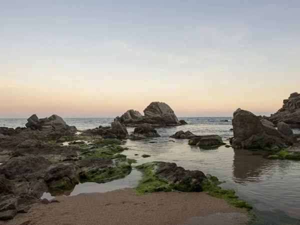 Lloret de Mar gün batımında plaj ve kayalar — Stok fotoğraf