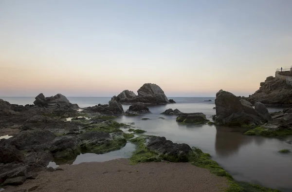 Playa y rocas al atardecer en Lloret de Mar — Foto de Stock