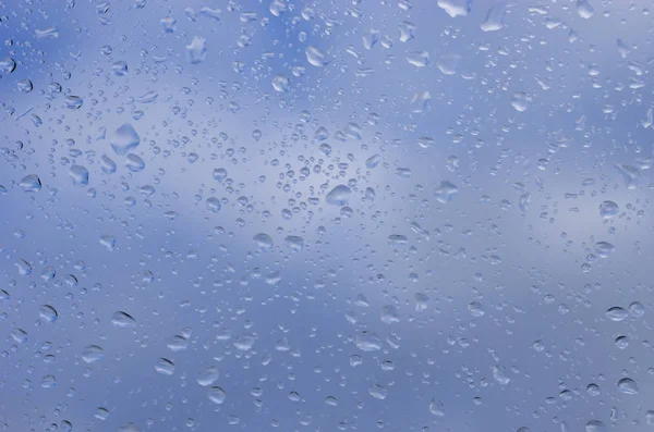 在蓝天的玻璃上的水滴 — 图库照片
