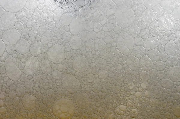 泡とグラスの中のビールの泡のクローズ アップ ビュー ストック写真