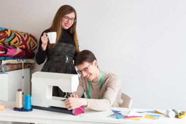 Aile iş, Meslek, ekipman kavramı. handy erkek ve kadın, kendi atelier üzerinde çalışan bir çift, ışık stüdyo donanımlı masa ve dikiş makinesi