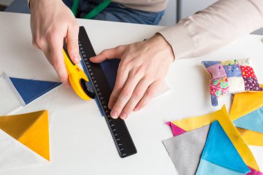 dikiş, kavram kapitone ekipman. yakın kadar uzun güzel parmaklarıyla erkek el vardır profesyonel terzi elinde, o farklı yamalar ile biraz-in onları dikiş için kesme çalışıyor