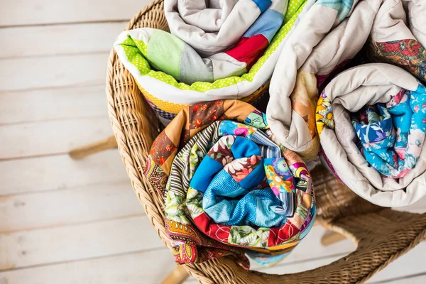 patchwork ve moda kavramı - closeup üç güzel yorgan üzerinde bir tüpün içine haddelenmiş ve bir hasır sandalye koydu, beyaz bir arka planda en iyi bitmiş ürün depolama görüntülemek, yat.