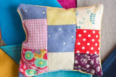 yama işi, yorgan dikme, terzilik ve moda konsepti - yakın plan güzel renkli dikişli yastık, mavi, gri ve kum kaplamalı yastık, düz yüz, üst görünüm.