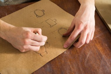 kağıt kalemle, el işi çalışmaları işçiliği üzerinde yemekler çizimi bir adamın elini. Yatay resim. hobi kavramı.