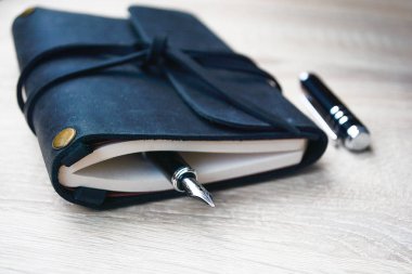 Erkekler iş amaçlı aksesuarları - bir siyah deri Not defteri, dolma kalem ofis masasında. İş ve eğitim.