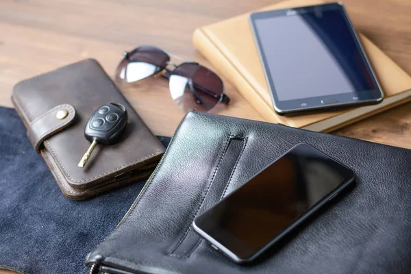 Erkek aksesuarlar - bir çanta, Gözlük, bir çanta, kartvizit, saat, Araba anahtarı, bir telefon, bir tablet, bir defter ve bir kalem ofis masasında. İş ve finans. Yaşam tarzı ve moda.