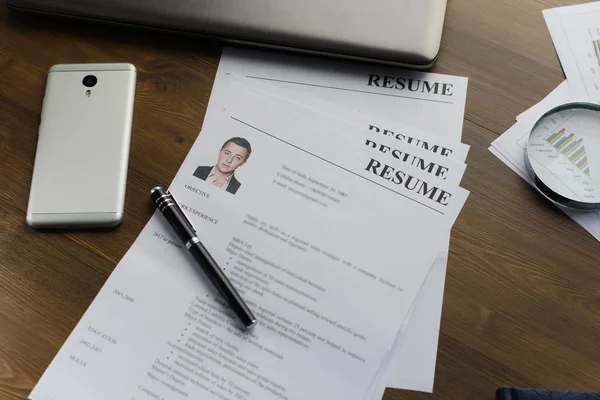 Resume (autobiography), pen, magnifier, laptop on your desktop. job search