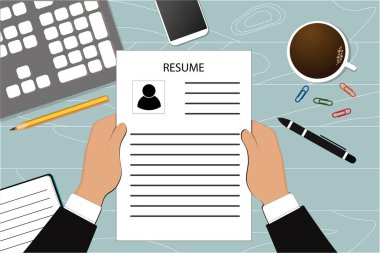 Bir kişi (iş adamı) masasındaki özgeçmişine bakar. Personel alımı, personel araması.