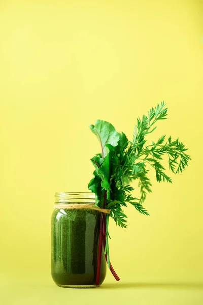Смузи со свеклой и морковными топами на желтом фоне, копировальное место. Летняя концепция веганской еды. Здоровое детоксикационное питание, щелочная диета. Свежий выжатый сок, напитки из овощей. Листья зелёные . — стоковое фото
