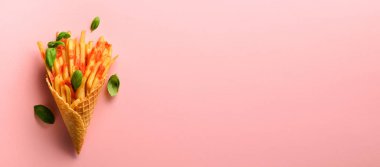 Gözleme koniler pembe bir arka plan üzerinde kızarmış patates. Sıcak tuzlu patates kızartması sos ile. Afiş. Fast food, abur cubur, diyet kavramı. Üstten görünüm. En az tarzı. Pop sanat tasarım, yaratıcı kavramı