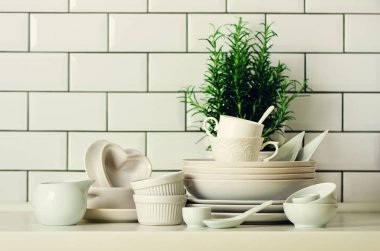 Beyaz sofra sunumu için. Yemekler, bardak, kaşık, mutfak eşyaları ve masa üstü diğer farklı beyaz şeyler. Mutfak aksesuarları. Uzay kopyalayın. Çok az ve temiz kavramı