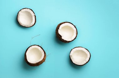 Mavi arka plan üzerinde olgunlaşmış hindistancevizi desenle. Üstten görünüm. Uzay kopyalayın. Pop sanat tasarım, yaratıcı yaz konsepti. Hindistan cevizi en az daire yatıyordu tarzı yarısı.