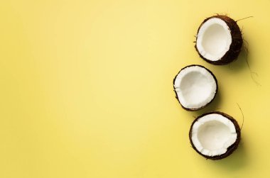 Desen sarı arka plan üzerinde olgunlaşmış hindistancevizi ile. Üstten görünüm. Uzay kopyalayın. Pop sanat tasarım, yaratıcı yaz konsepti. Hindistan cevizi en az daire yatıyordu tarzı yarısı.