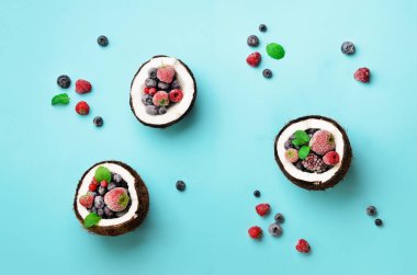 Taze organik çilek, kopya alanı ile mavi arka plan üzerinde olgunlaşmış hindistancevizi içinde nane yaprakları. Üstten görünüm. Pop sanat tasarım, yaratıcı yaz konsepti. Hindistan cevizi en az daire yatıyordu tarzı yarısı.