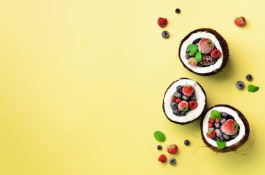 Taze organik çilek, kopya alanı sarı zemin üzerine nane yaprakları olgunlaşmış hindistancevizi içinde. Üstten görünüm. Pop sanat tasarım, yaratıcı yaz konsepti. Hindistan cevizi en az daire yatıyordu tarzı yarısı.