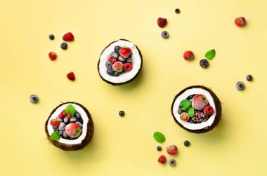 Taze organik çilek, kopya alanı sarı zemin üzerine nane yaprakları olgunlaşmış hindistancevizi içinde. Üstten görünüm. Pop sanat tasarım, yaratıcı yaz konsepti. Hindistan cevizi en az daire yatıyordu tarzı yarısı.