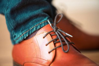 Ahşap parke arka plan üzerinde kahverengi deri ayakkabıları ayakkabı bağcığı.