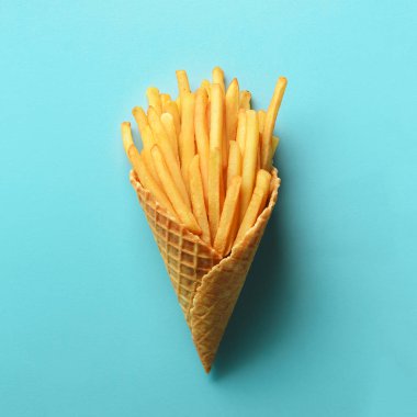 Gözleme koniler mavi zemin üzerine kızarmış patates. Domates soslu sıcak tuzlu kızarmış patates. Fast food, abur cubur, diyet kavramı. Üstten görünüm. En az tarzı. Pop sanat tasarım, yaratıcı kavramı.