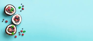 Taze organik çilek, kopya alanı ile mavi arka plan üzerinde olgunlaşmış hindistancevizi içinde nane yaprakları. Üstten görünüm. Pop sanat tasarım, yaratıcı yaz konsepti. Hindistan cevizi en az daire yatıyordu tarzı yarısı.