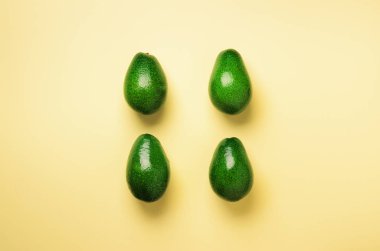 Sarı zemin üzerine yeşil avokado desen. Üstten görünüm. Pop sanat tasarım, yaratıcı yaz gıda kavramı. Organik avocadoes en az daire yatıyordu tarzı.