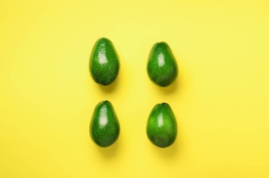 Sarı zemin üzerine yeşil avokado desen. Üstten görünüm. Pop sanat tasarım, yaratıcı yaz gıda kavramı. Organik avocadoes en az daire yatıyordu tarzı.