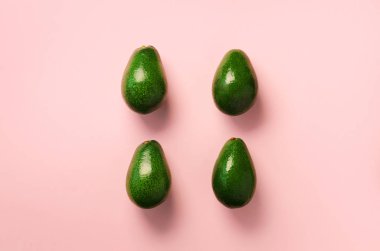 Pembe bir arka plan üzerinde yeşil avokado desen. Üstten görünüm. Pop sanat tasarım, yaratıcı yaz gıda kavramı. Organik avocadoes en az daire yatıyordu tarzı.