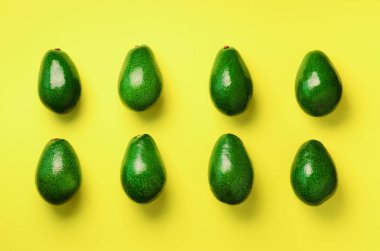 Sarı zemin üzerine yeşil avokado desen. Üstten görünüm. Pop sanat tasarım, yaratıcı yaz gıda kavramı. Organik avocadoes en az daire yatıyordu tarzı.