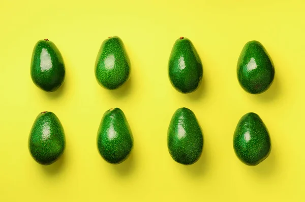 Patrón de aguacate verde sobre fondo amarillo. Vista superior. Diseño de arte pop, concepto creativo de comida de verano. Aguacates orgánicos en estilo laico plano mínimo . — Foto de Stock