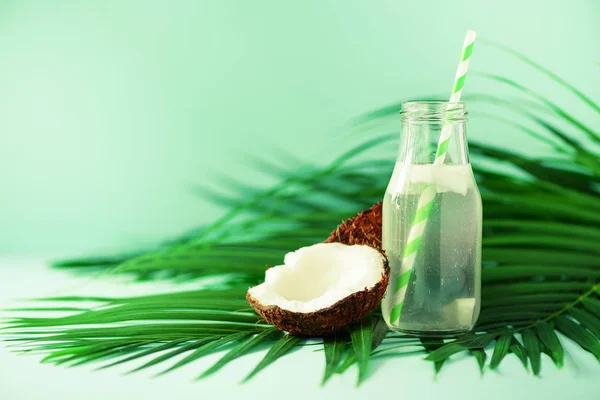 Garrafa de água de coco e frutas frescas maduras em fundo azul. Conceito de comida de verão. Vegetariano, vegan, bebida de desintoxicação. Suco de coco com palha em folhas de palma — Fotografia de Stock