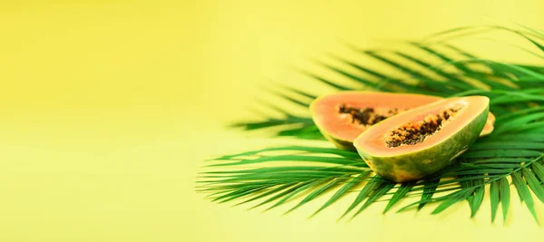 木瓜果在热带绿色棕榈叶上黄色的背景。复制空间。流行艺术设计, 创意夏日概念。纯素食的食物。旗帜. — 图库照片