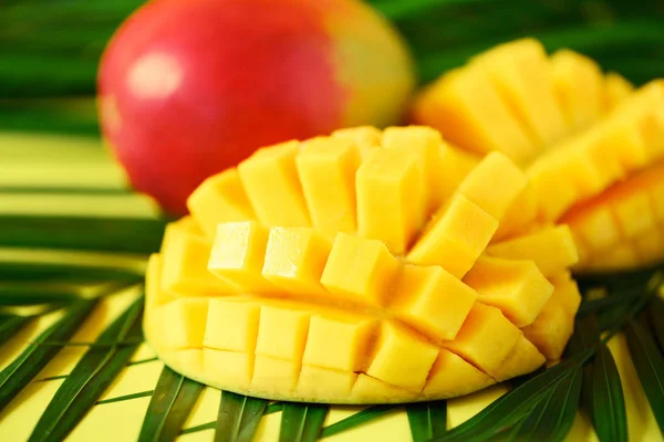 Exotic mango fruit over tropical green palm leaves on yellow background. Copy space. Pop art design, creative summer concept. Banner — Stock Photo, Image