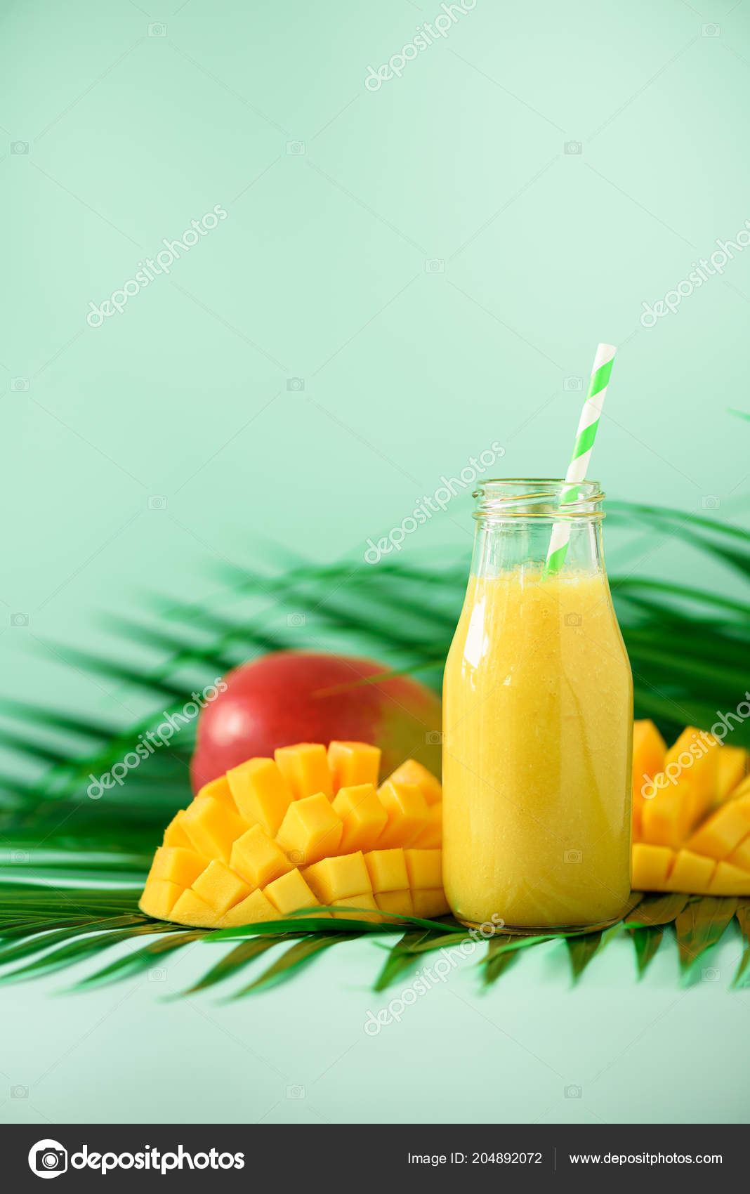 Delicious juicy smoothie with orange fruit and mango on turquoise