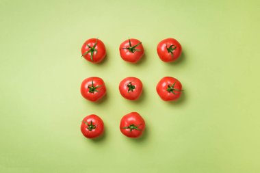 Yeşil zemin üzerine kırmızı domates yaratıcı deseni. Üstten görünüm. Uzay kopyalayın. Minimal tasarım. Vejetaryen, vegan, organik gıda ve alkali yemek kavramı