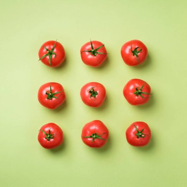 Yeşil zemin üzerine kırmızı domates yaratıcı deseni. Üstten görünüm. Uzay kopyalayın. Minimal tasarım. Vejetaryen, vegan, organik gıda ve alkali yemek kavramı