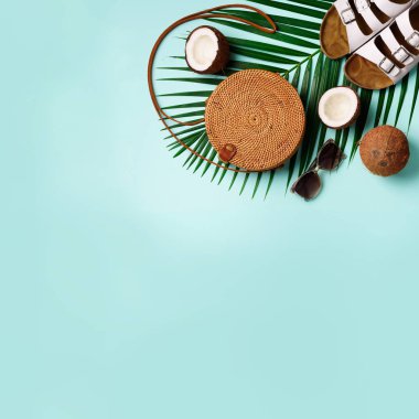 Rattan çanta, Hindistan cevizi, birkenstocks, hurma dalları güneş gözlüğü üzerinde arka plan mavi. Kare ürün. Görünümü en çok, uzay kopyalayın. Trendy bambu çanta ve ayakkabılar. Yaz moda düz yatıyordu. Gezi, tatil kavramı