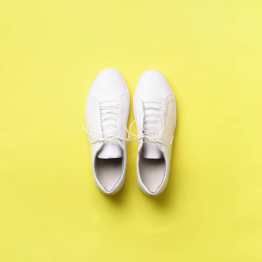 Şık beyaz spor ayakkabı ve ip kopya alanı sarı zemin üzerine. Üstten görünüm. En az düz yatıyordu. Yaz Ayakkabı koleksiyonu. İlk adım kavramı. Kare kırpma