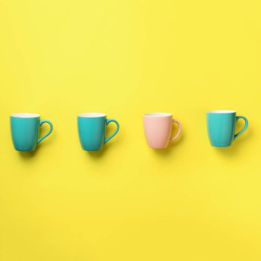 Mavi ve pembe su bardağı sarı arka plan üzerinde desen. Kare ürün. Doğum günü partisi kutlama, bebek duş kavramı. Punchy pastel renkler. Minimalist tarzı tasarım