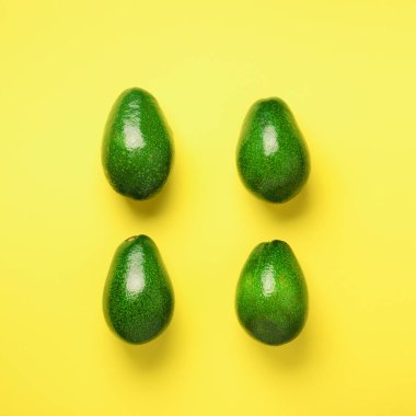 Sarı zemin üzerine yeşil avokado desen. Üstten görünüm. Kare ürün. Pop sanat tasarım, yaratıcı yaz gıda kavramı. Organik avocadoes en az daire yatıyordu tarzı.