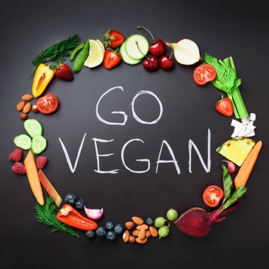 Sağlıklı gıda arka plan. Daire taze sebze, meyve, fındık, çilek el yazısı ile siyah kara tahta gitmek Vegan ifade. Kare ürün. Üstten görünüm. Vegan, detoks ve temiz yemek kavramı