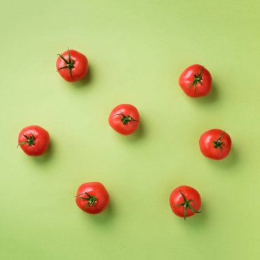 Yeşil zemin üzerine kırmızı domates yaratıcı deseni. Üstten görünüm. Uzay kopyalayın. Kare ürün. Minimal tasarım. Vejetaryen, vegan, organik gıda ve alkali yemek kavramı