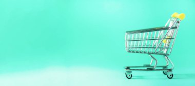 Alışveriş sepeti mavi zemin üzerine. Minimalizm tarzı. Yaratıcı tasarım. Uzay kopyalayın. Afiş. Süpermarkette alışveriş arabası. Satış, iskonto, shopaholism kavramı. Tüketici Derneği eğilim