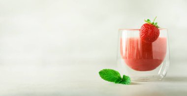 Berry yüzlü cam kopya alanı ile gri arka plan üzerinde. Yaz yiyecek ve temiz kavramı, vegan diyet yemek. Pembe detoks İçecek taze çilek ile