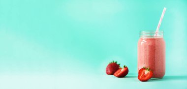 Şişe vegan çilek yüzlü kopya alanı ile mavi arka plan ile. Afiş. Yaz gıda kavramı, vegan diyet. Taze çilek ile pembe yüzlü