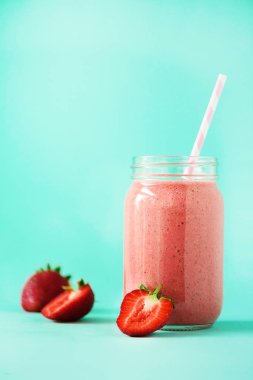 Şişe vegan çilek yüzlü kopya alanı ile mavi arka plan ile. Yaz gıda kavramı, vegan diyet. Taze çilek ile pembe yüzlü