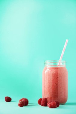 Pembe ahududu milkshake cam kopya alanı ile mavi arka plan üzerinde. Yaz gıda kavramı, vegan diyet. Taze çilek ile pembe yüzlü