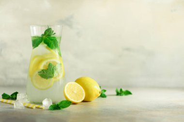 Narenciye limonata - buz, nane, limon gri arka plan üzerine soğuk su. İçki detoks. Yaz meyve su infüzyon. Kopya alanı.