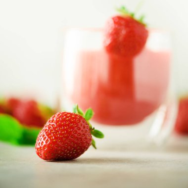 Vegan çilek yüzlü kopya alanı ile gri arka plan üzerinde bardak. Kare ürün. Yaz yiyecek ve temiz kavramı, vegan diyet yemek. Pembe detoks İçecek taze çilek ile